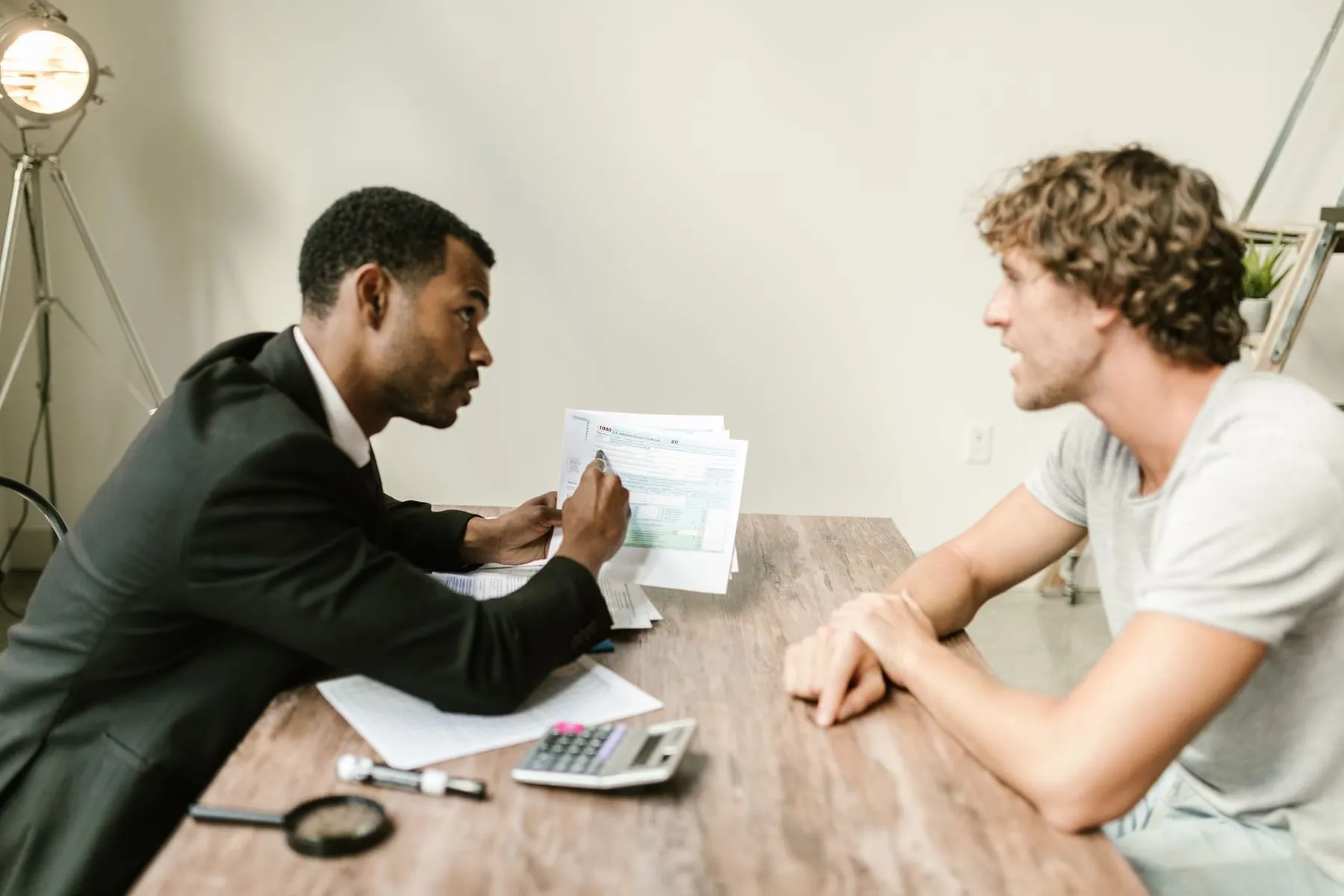 An agent handing a document across a desk to a client