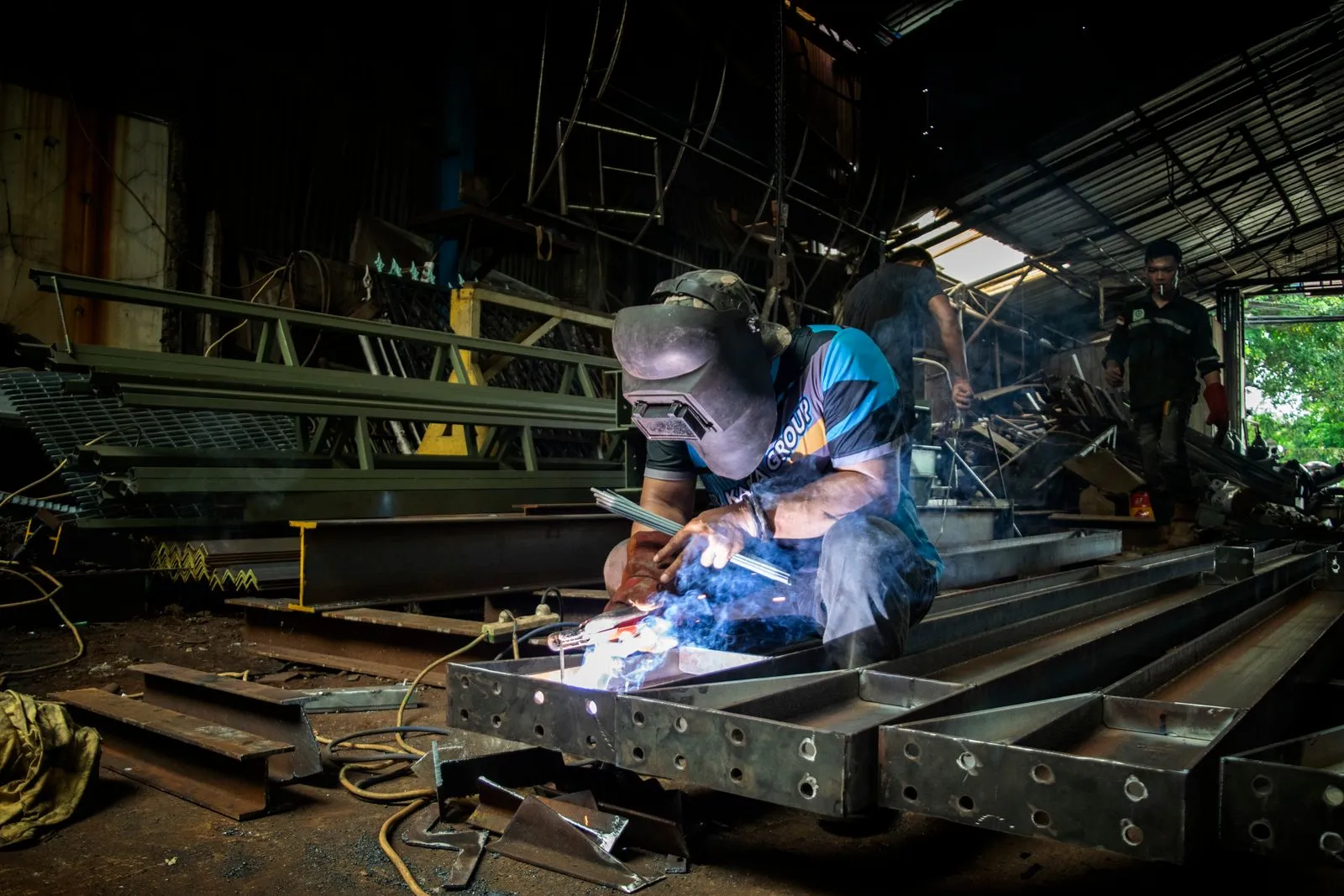 A welder working on metal in a fabrication shop