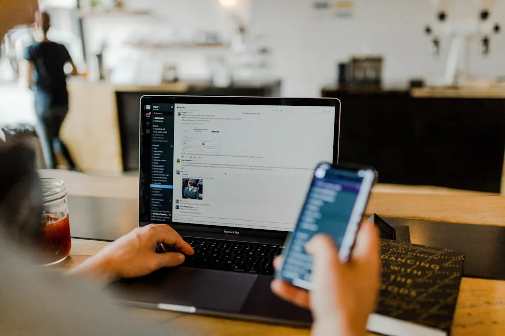 A phone held beside a laptop
