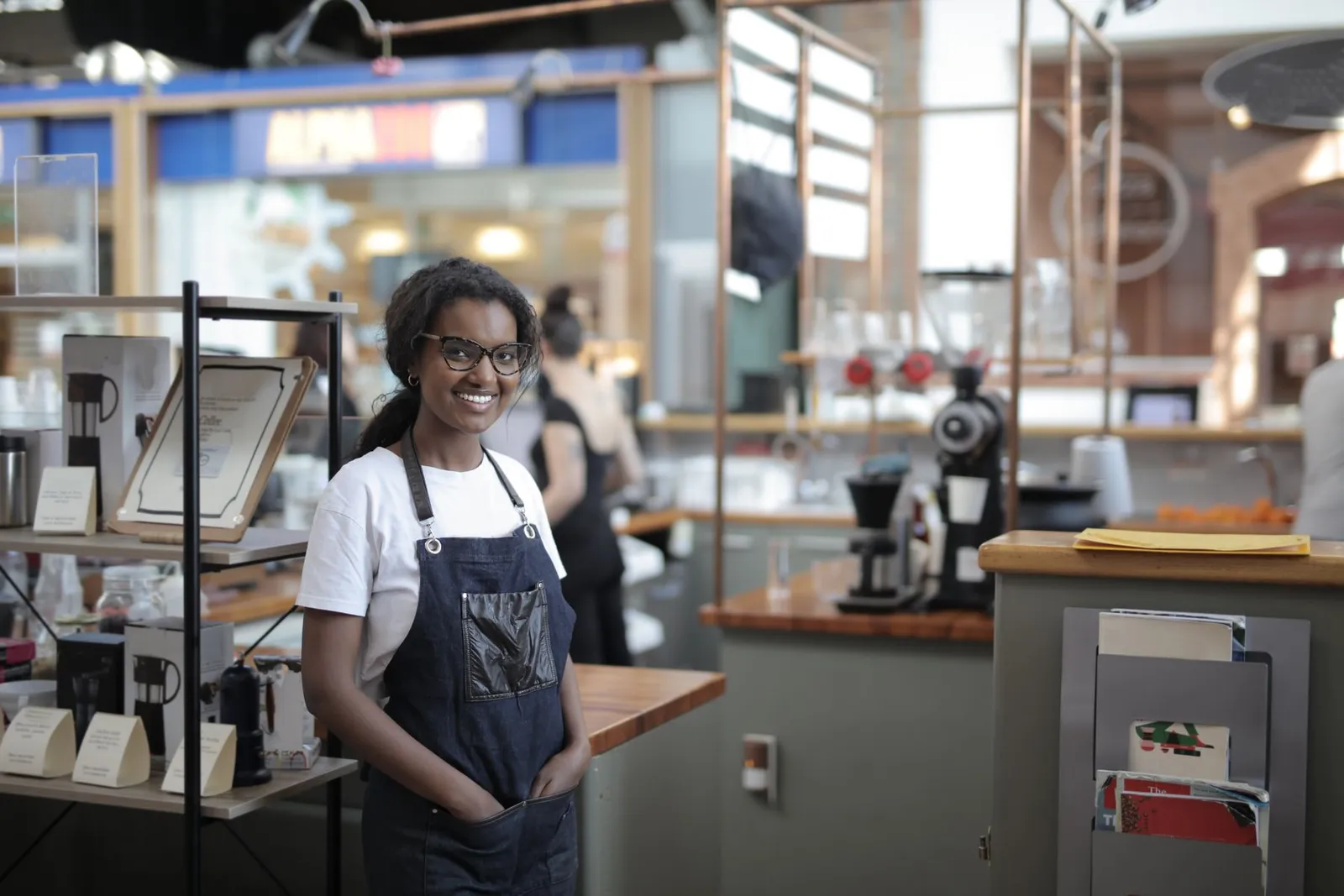 A caf&eacute; owner standing among the shelves of her shop